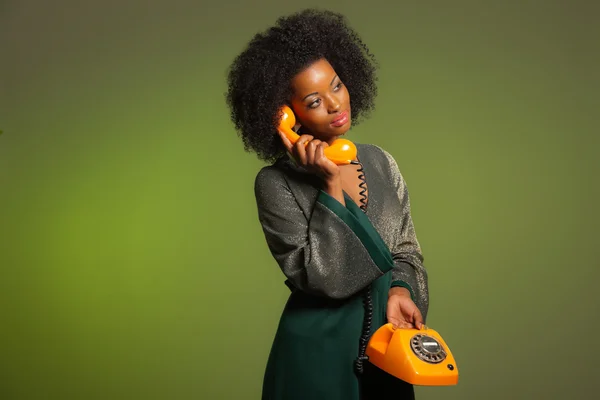 Retro 70s afro fashion woman with green dress. Calling with oran — Stock Photo, Image