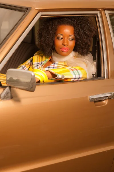 Retro 70 moda afroamericana mujer conduciendo en oro seventi —  Fotos de Stock