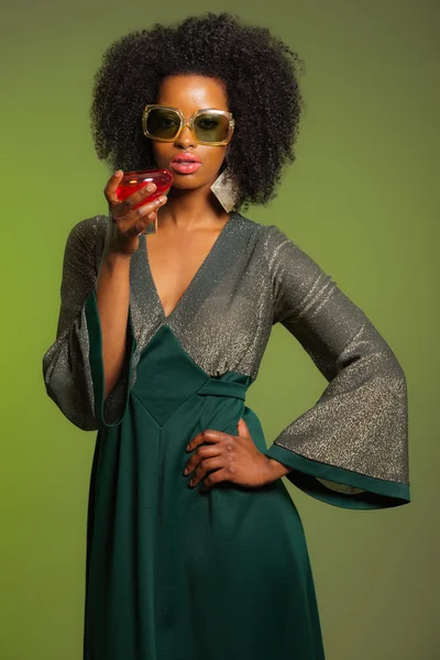 Retro 70s afro fashion woman with green dress and orange cocktai — Stock Photo, Image