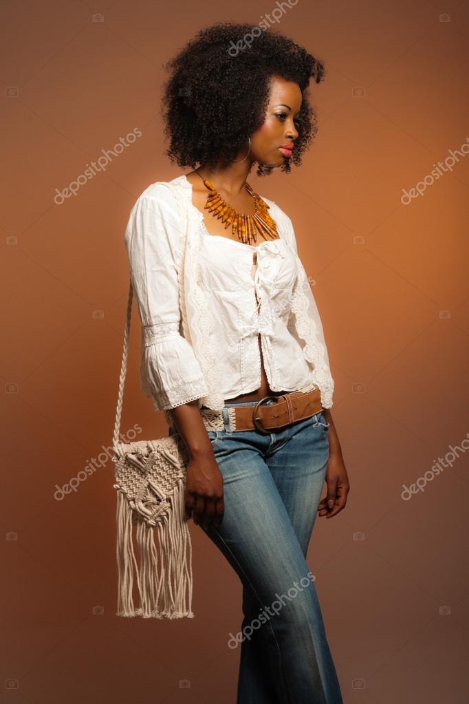 Vintage 70s fashion afro woman. White shirt and jeans against br Stock  Photo by ©ysbrand 26782635