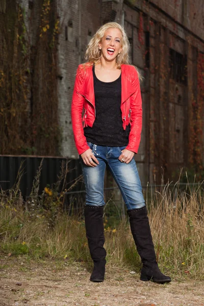 Knappe jonge vrouw met lang blond haar en rode jas. stedelijke — Stockfoto