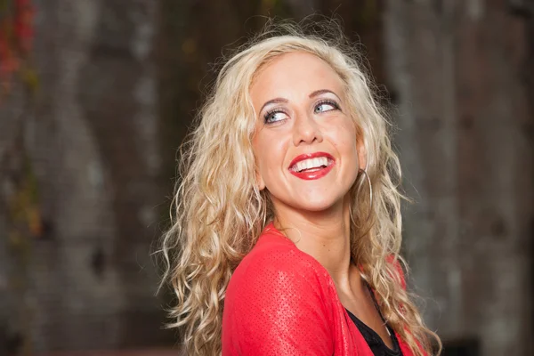 Hübsche junge Frau mit langen blonden Haaren und roter Jacke. städtisch — Stockfoto