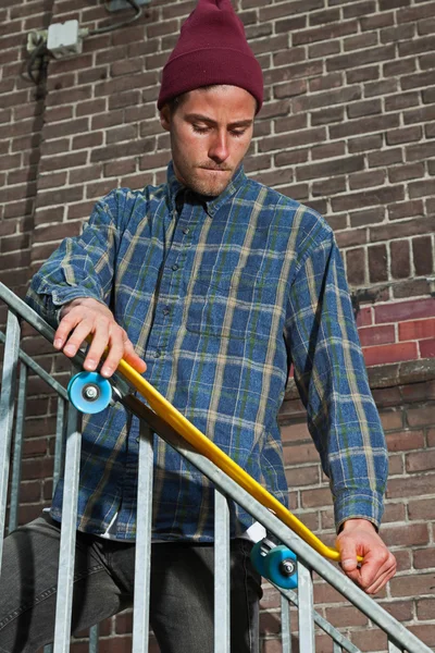 Cooler hipper Skateboarder mit Wollmütze kontrolliert die Eisenschiene — Stockfoto