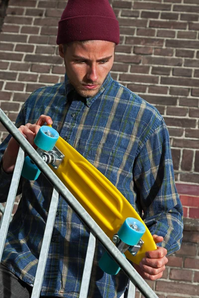 Cooler hipper Skateboarder mit Wollmütze kontrolliert die Eisenschiene — Stockfoto