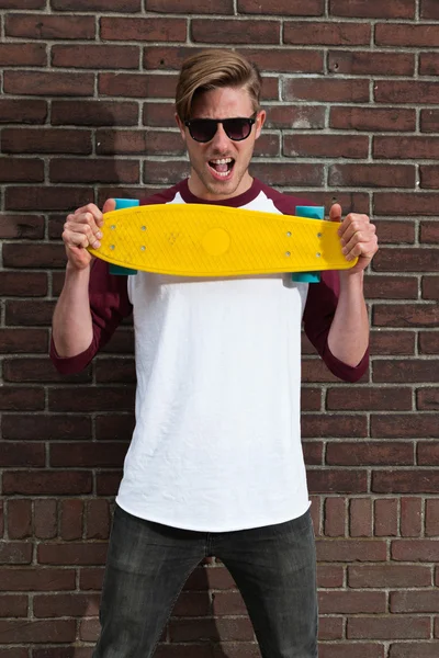 Skateboarder αστικής μόδας με γυαλιά ηλίου που θέτουν μπροστά από br — Φωτογραφία Αρχείου