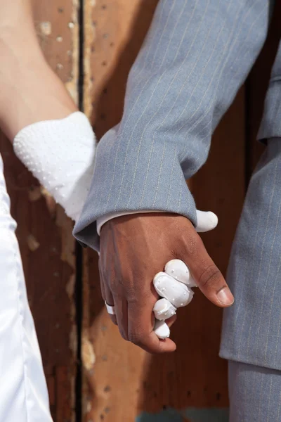 Närbild av håller händerna på eleganta brudparet. blandras. — Stockfoto