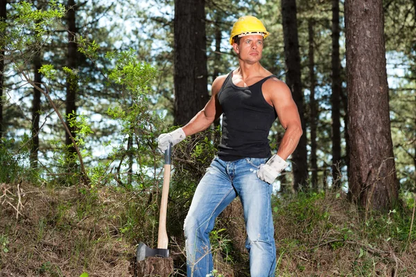 Muscled skogshuggare med svart skjorta och yxa i skogen. bär y — Stockfoto