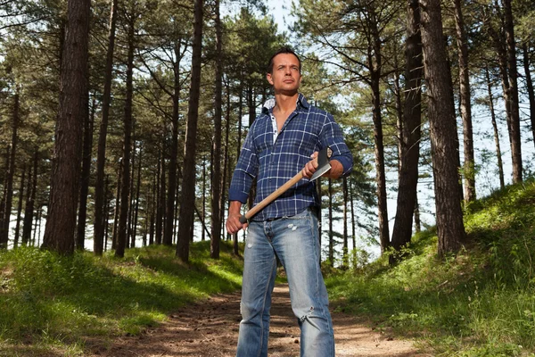 Guapo y fuerte leñador sosteniendo hacha. El uso de camisa azul . —  Fotos de Stock