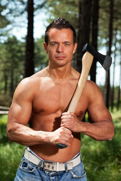 Shirtless muscled fitness lumberjack man with axe in forest. — Stock Photo, Image