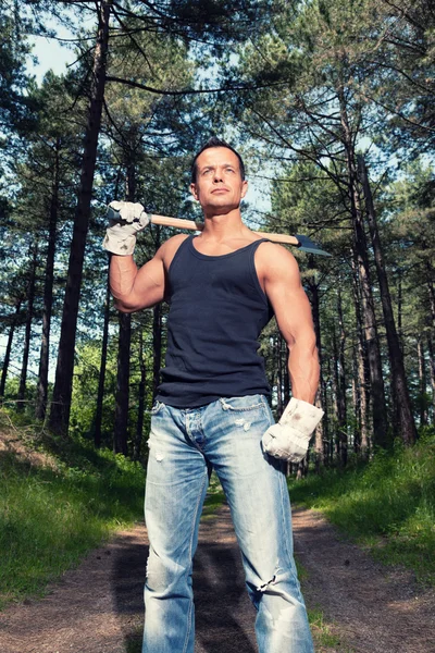 Muskulöser Mann mit schwarzem Hemd und Axt im Wald. — Stockfoto
