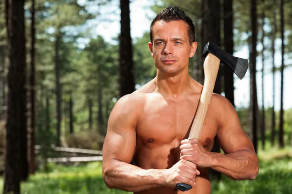 Hemdlos muskulöser Fitness-Holzfäller mit Axt im Wald. — Stockfoto