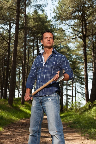 Guapo y fuerte leñador sosteniendo hacha. El uso de camisa azul . —  Fotos de Stock