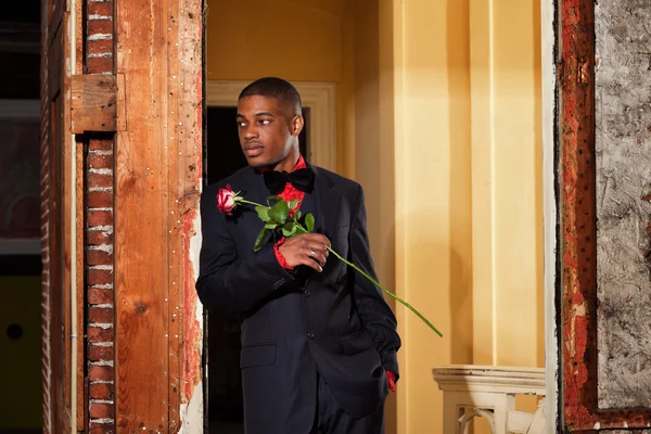 Vintage-Mode afroamerikanischer Bräutigam mit roter Rose. stehend i — Stockfoto