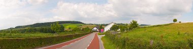 Road hill manzara mavi bulutlu gökyüzü ile. panoramik çekim. zui