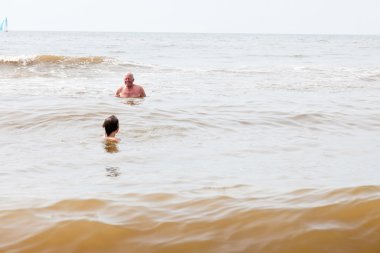 Denizde yüzme Dede genç çocuk. Dalgalar zevk.