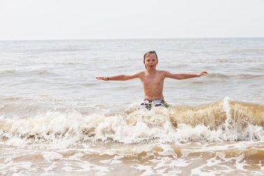 Okyanus dalgaları plajda eğlenmek çocuk çocuk.