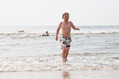 genç çocuk dışarı su Sahilde yürüyüş.