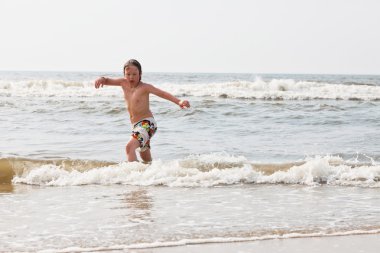 su sahilde duran genç çocuk.