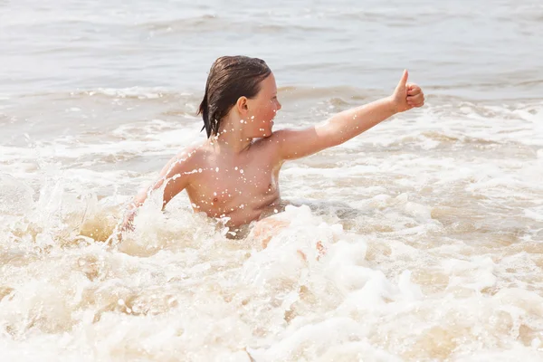 Chłopiec dziecko, zabawy na plaży, fale oceanu. — Zdjęcie stockowe