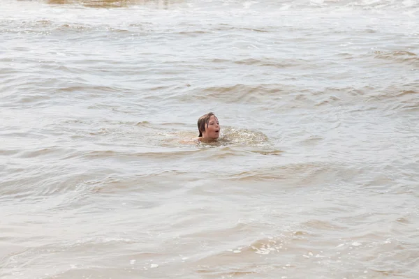 Хлопчик розважається на пляжі в хвилях океану . — стокове фото