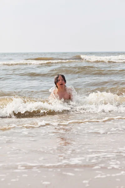 Gyerek fiú szórakozás a strandon, a hullámok az óceánon. — Stock Fotó