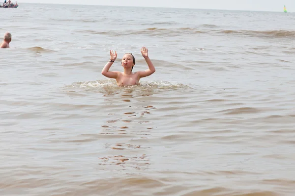 Mladej kluk baví v oceánu s vlnami. — Stock fotografie