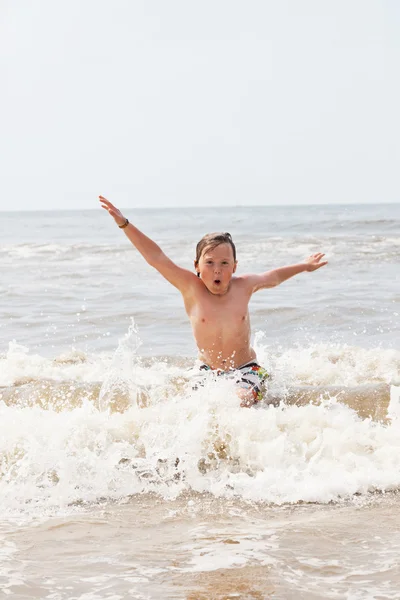 Kid boy having fun at the beach in the waves of the ocean. — Stock Photo, Image