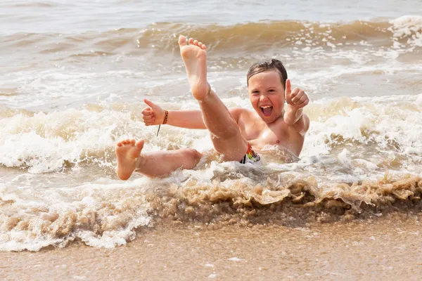 海の波のビーチで楽しんで子供男の子. — ストック写真