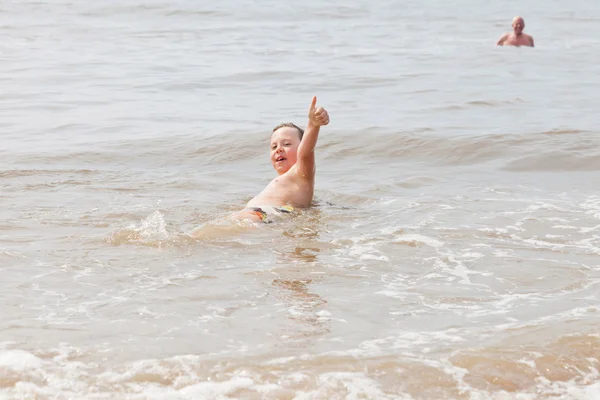 Young boy and grandpa swimming in the ocean. Enjoying the waves. — Stock Photo, Image