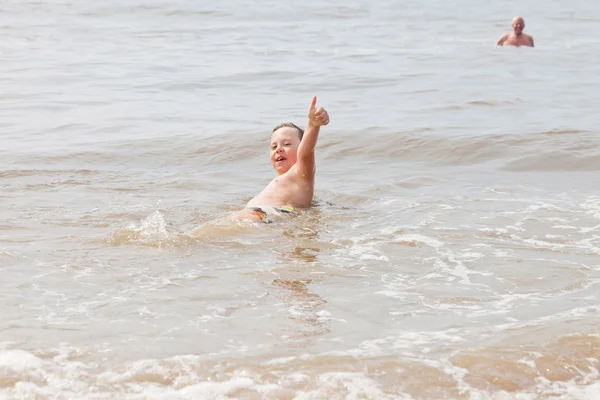 Rapaz e avô nadando no oceano. Aproveitando as ondas . — Fotografia de Stock