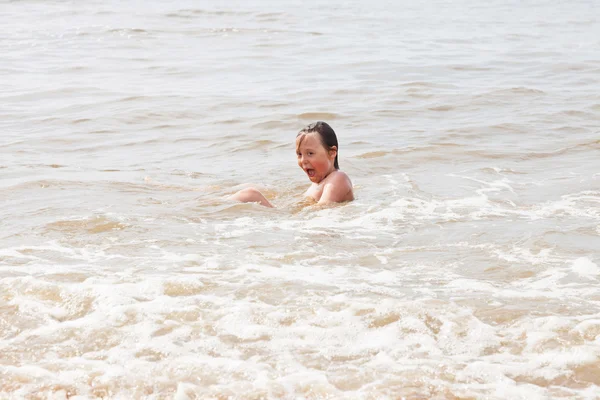 One young boy playing in the ocean with waves. — Stock Photo, Image