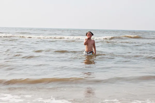 Garoto se divertindo na praia nas ondas do oceano . — Fotografia de Stock