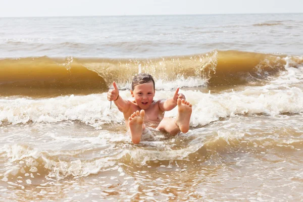 Chłopiec dziecko, zabawy na plaży, fale oceanu. — Zdjęcie stockowe