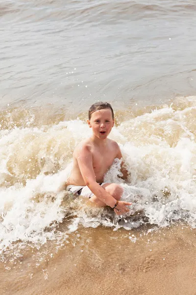 Ragazzo che si diverte in spiaggia tra le onde dell'oceano . — Foto Stock