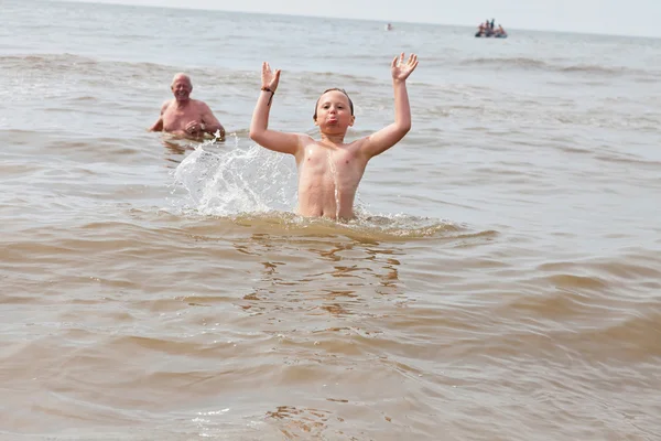 Νεαρό αγόρι και ο παππούς, κολύμπι στον ωκεανό. απολαμβάνοντας τα κύματα. — Φωτογραφία Αρχείου