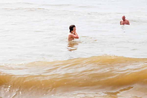 Rapaz com o avô a nadar no mar. Aproveitando as ondas . — Fotografia de Stock