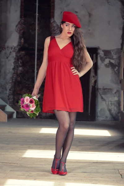 Sensual sexy bride wearing red dress and hat standing in old hou — Stock Photo, Image