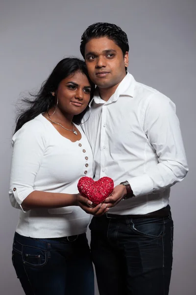 Ρομαντικό ινδική ζευγάρι κρατώντας την κόκκινη καρδιά. φορώντας άσπρο πουκάμισο μια — Φωτογραφία Αρχείου