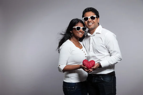 Romantic indian couple holding red heart. Wearing white shirt an — Stock Photo, Image