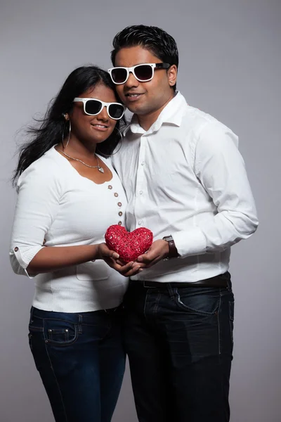 Pareja romántica india sosteniendo el corazón rojo. Usando camisa blanca y — Foto de Stock