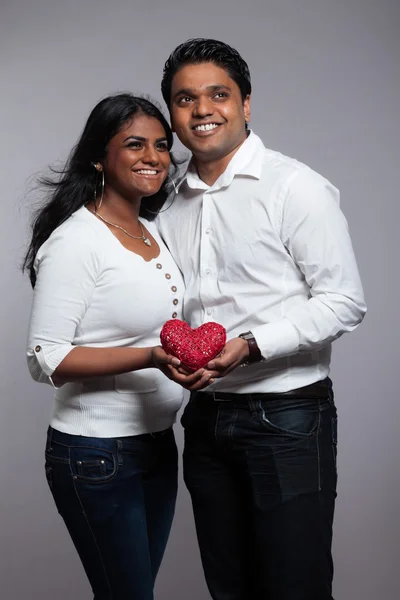 Romantic indian couple holding red heart. Wearing white shirt an — Stock Photo, Image