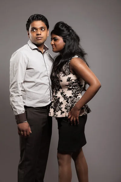 Modieuze gepassioneerd Indiase paar. studio opname tegen grijs. — Stockfoto