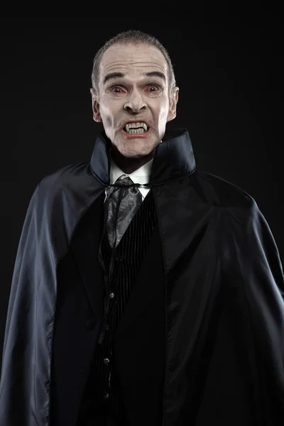 Drácula con capa negra mostrando sus dientes aterradores. Colmillos vampiros. Stu. —  Fotos de Stock