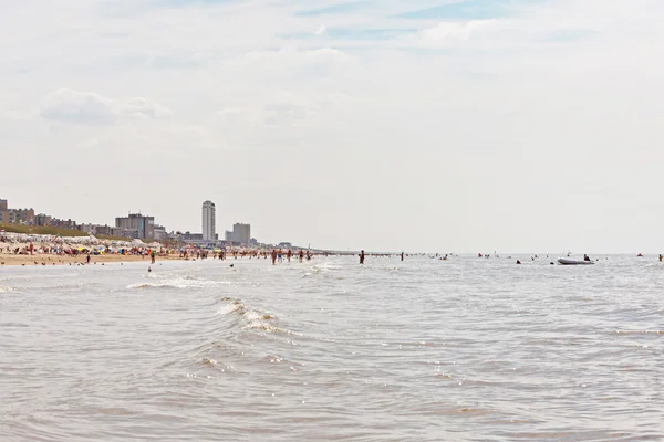 Mer avec touristes et horizon des hôtels. Ciel nuageux bleu. Zandvo — Photo