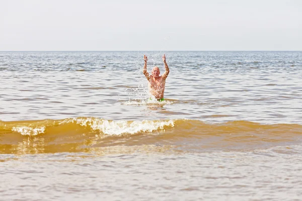 Single retired senior man enjoying the refreshment of the sea on — Stock Photo, Image