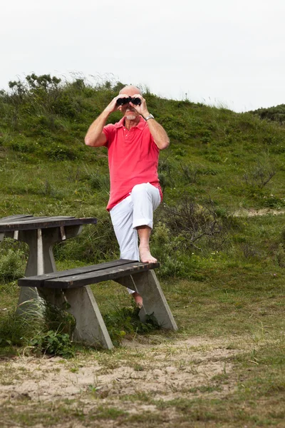 Nyugdíjas férfi szakáll és szemüveg segítségével távcsövet szabadban, a — Stock Fotó
