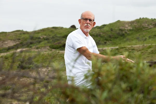 Retired man with beard and glasses resting and having lunch in g — Stock Photo, Image