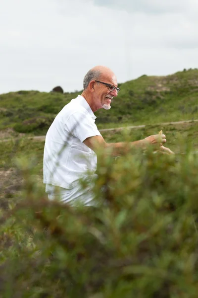 Retired man with beard and glasses resting and having lunch in g — Stock Photo, Image