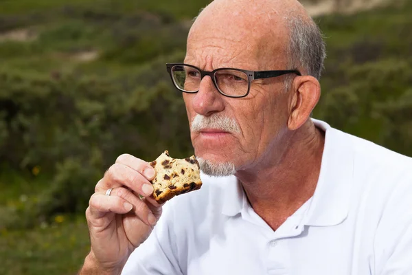 Uomo in pensione con barba e occhiali che riposa e pranza in g — Foto Stock