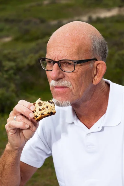 Gepensioneerde man met baard en glazen rusten en na de lunch in g — Stockfoto